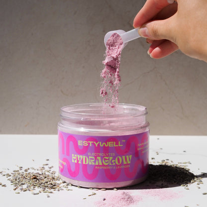 Estywell Hydraglow elektrolyty s levandulovou a malinovou príchuťou – detail otvoreného balenia s odmerkou.