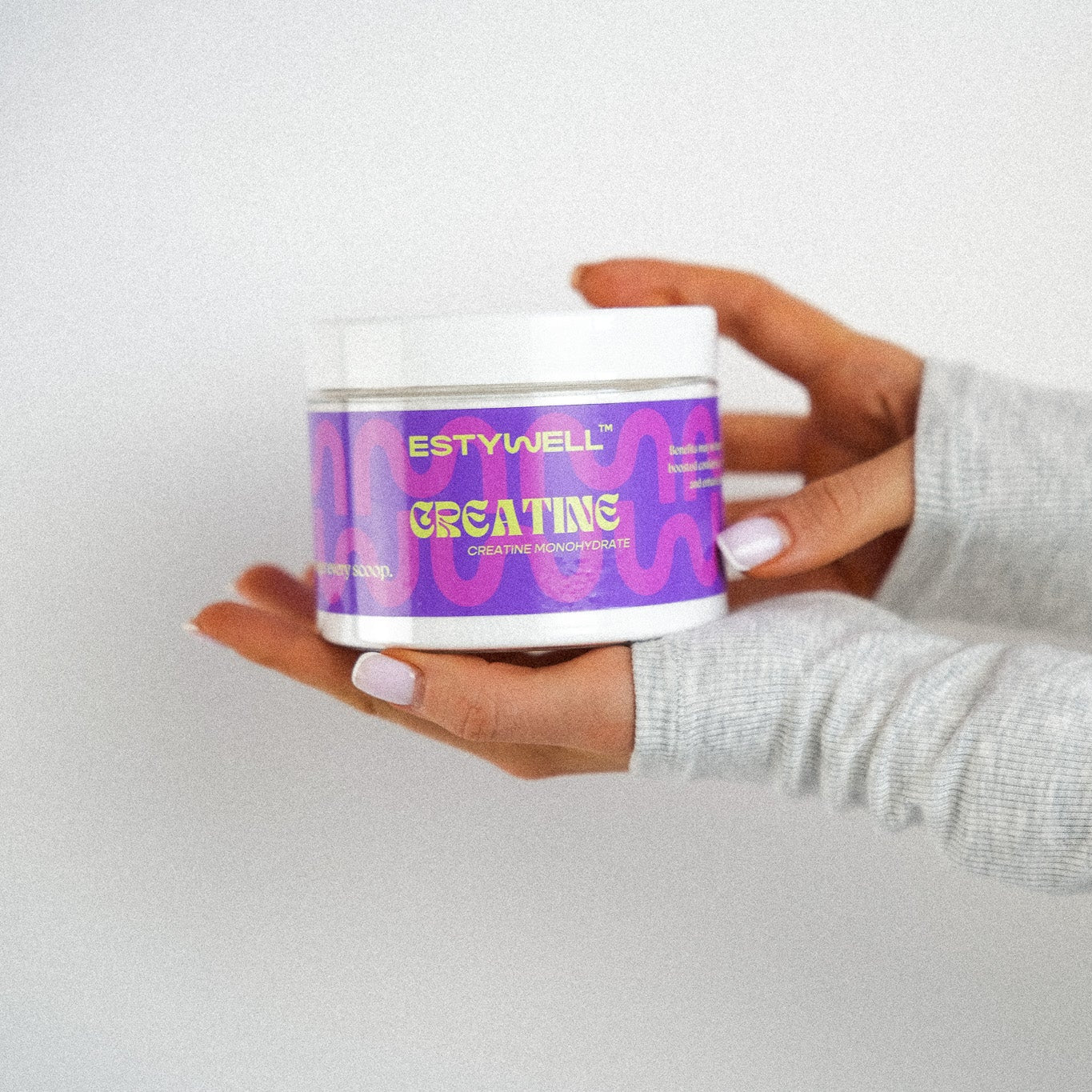 Estywell kreatín monohydrát - balenie produktu držiaci v ruke.