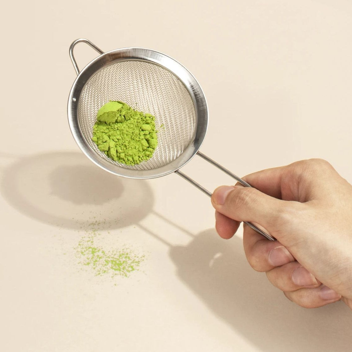 Preosievanie ceremoniálnej matche cez nerezové sitko